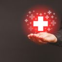 Health care and business health insurance concept. Virtual medical icons on the palm businessman against a gray background. Space for text
